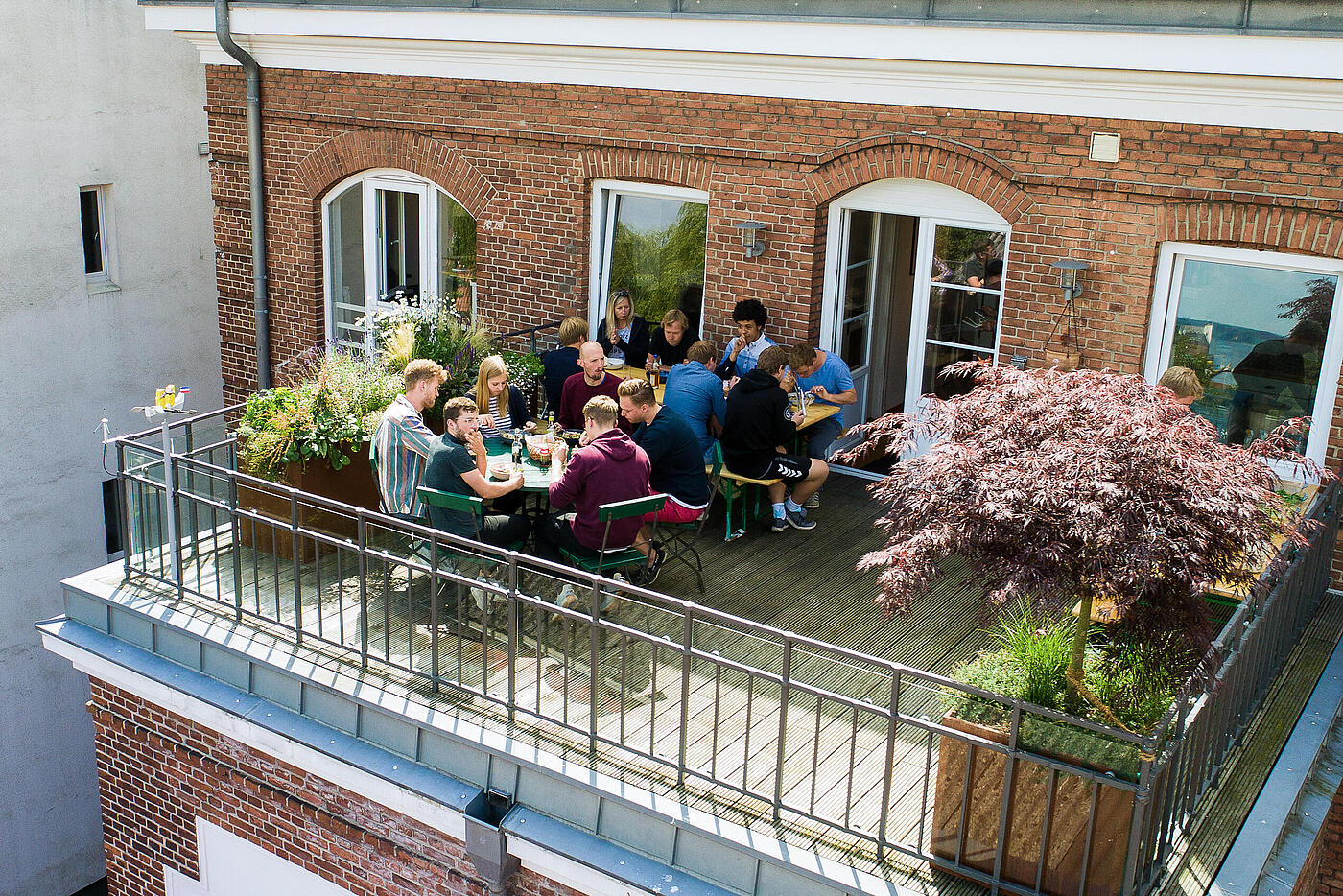 Der einladende Balkon der Werbeagentur visuellverstehen, auf dem Mitarbeitende zu Mittag essen.