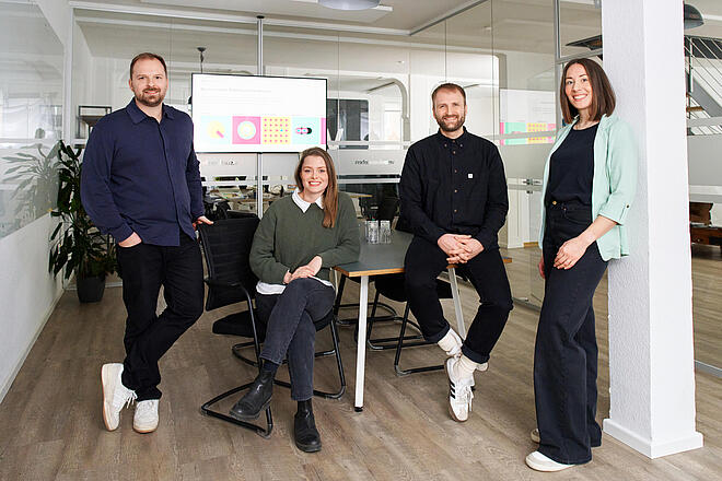 Sören Riechmann, Lea Lenz, Malte Riechmann und Frauke Hellwig in einem Besprechungsraum bei visuellverstehen.