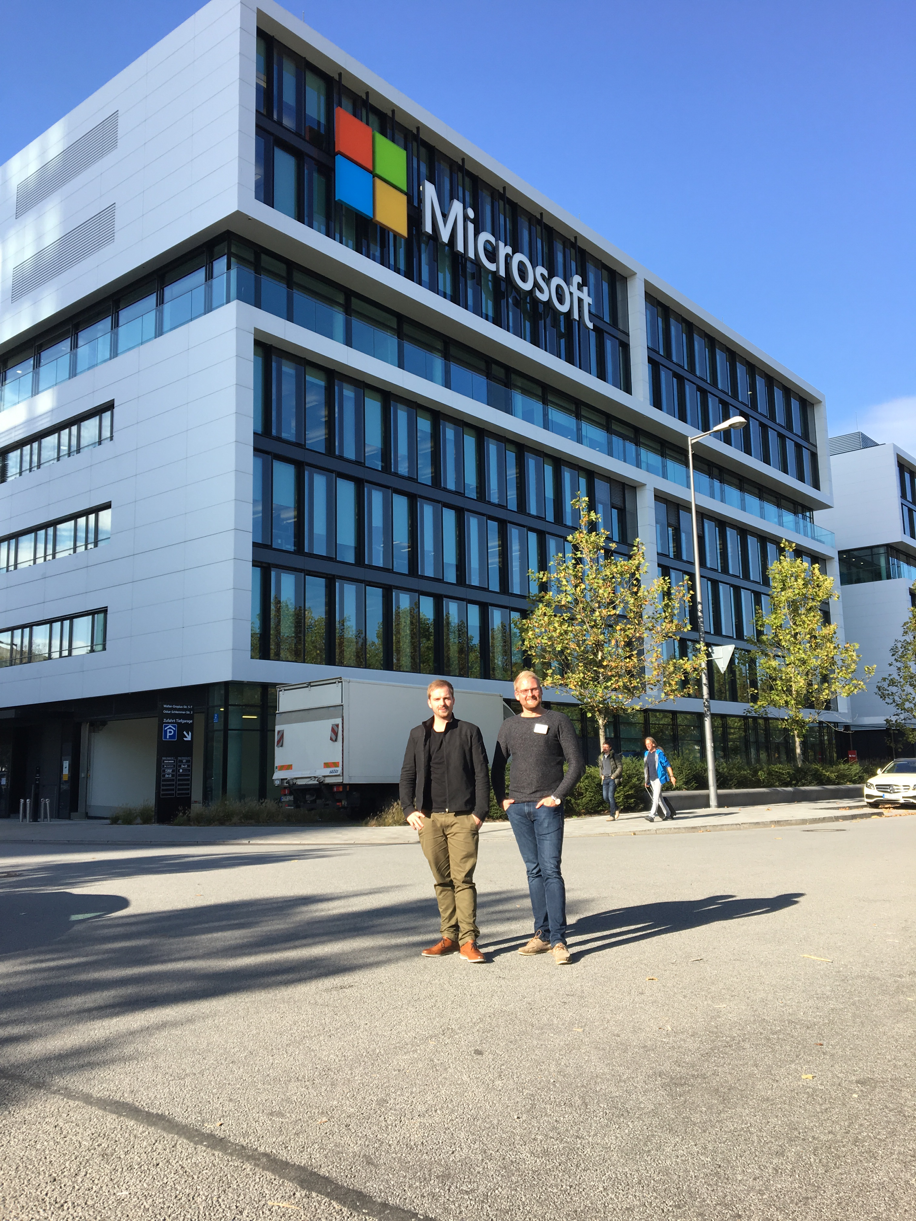 Zwei Mitarbeiter von visuellverstehen stehen beim Agenturcamp 2017 vor dem Microsoft-Gebäude in München. 